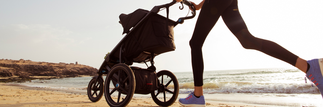 Woman running with stroller on the beach